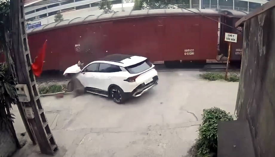 Clip TNGT: Bất cẩn không quan sát, tài xế KIA Sportage bị tàu hoả kéo văng xuống vệ đường